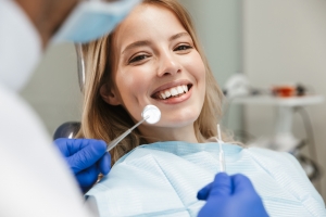 Zufriedene Frau die ihre Zähne gesäubert vom Zahnarzt bekommt